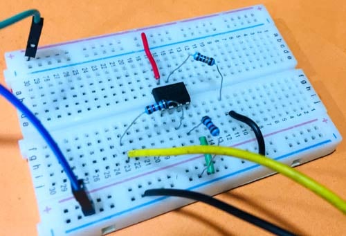 Physical hardware implementation of zero crossing detector circuit on breadboard showing LM741 op-amp, transformer connections, resistors, and power supply connections for practical circuit construction