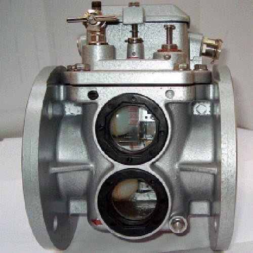 Buchholz gas detection relay installed between main transformer tank and conservator with gas flow arrow, sampling valves, and float switch mechanism for transformer fault detection