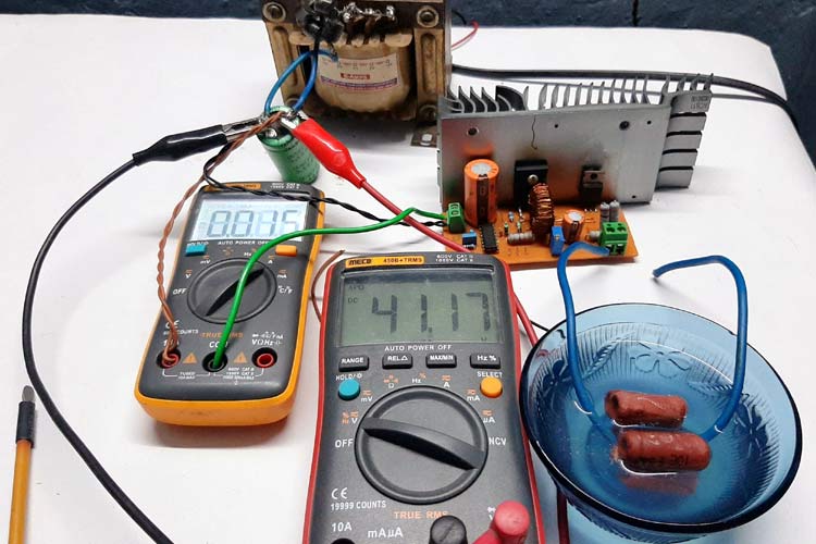 Buck-Converter-Test-Setup.png with alt text: "High voltage buck regulator testing setup with multimeters and oscilloscope