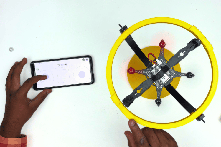 Finished homemade drone test stand with mini quadcopter mounted using Velcro strap