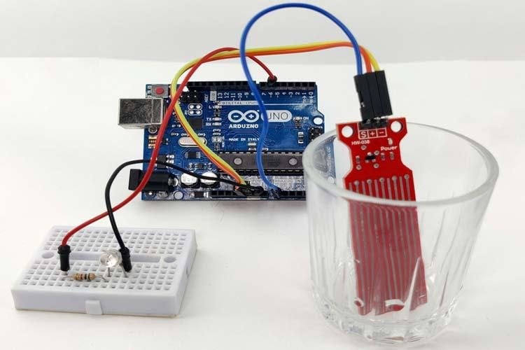 Assembled water level sensor project with Arduino UNO breadboard and LED on workbench